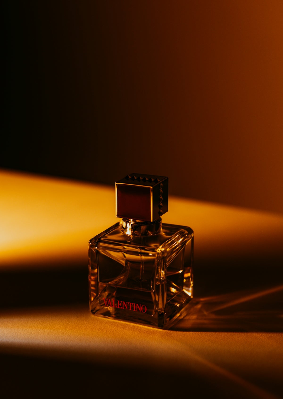 A bottle of valentino cologne with dramatic lighting